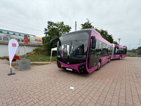 Ein verkehrspurpurfarbener Ersatzverkehrsbus parkt zur Besichtigung vor dem Bahnhof Nauen.