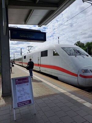 Fahrgäste steigen am Bahnhof Büchen in einen ICE. Ein Aufsteller mit Plakat weist am Bahnsteig auf den Ersatzverkehr während der Generalsanierung hin.